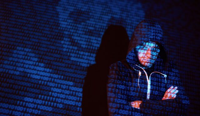 Cyber attack with unrecognizable hooded hacker using virtual reality, digital glitch effect