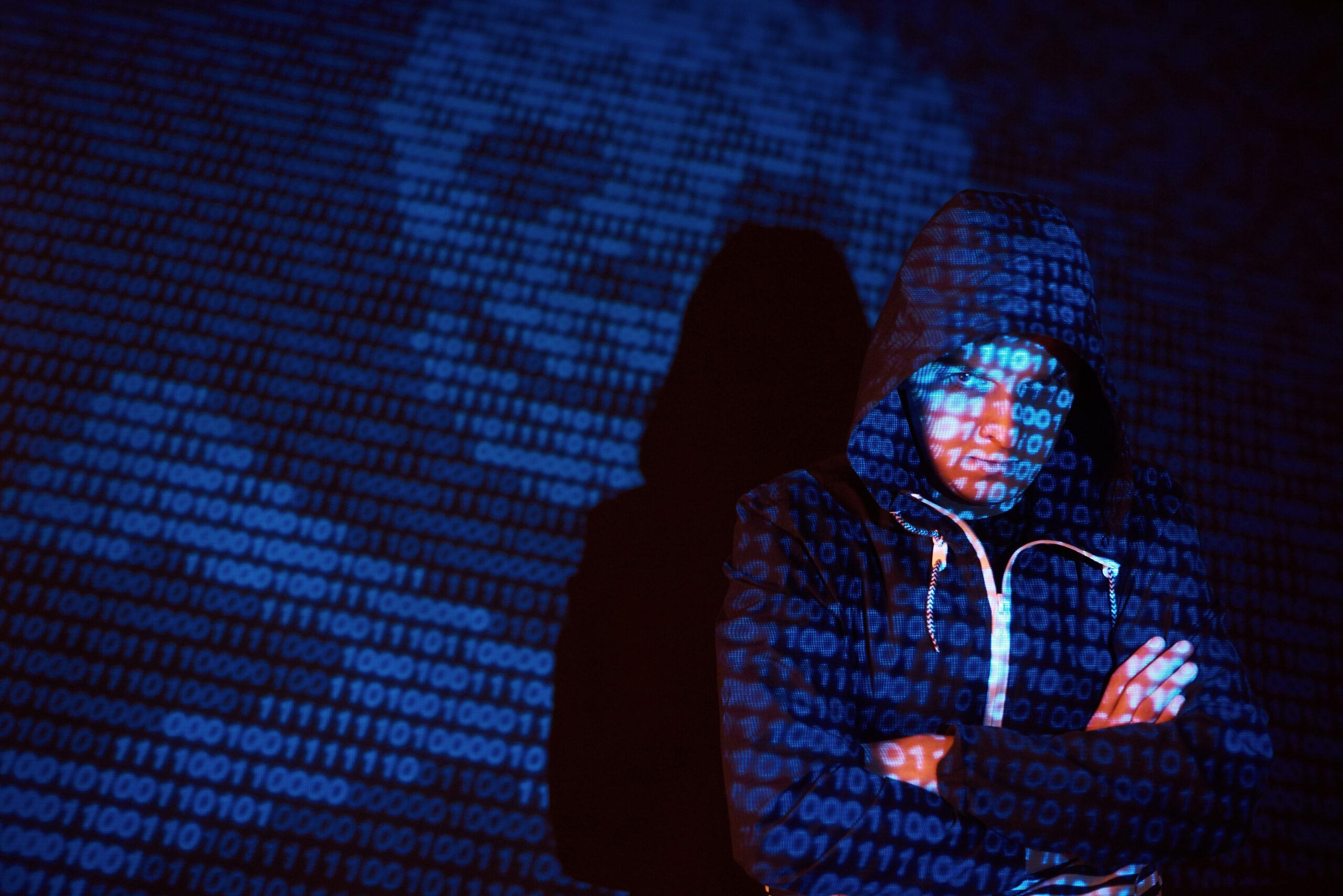 Cyber attack with unrecognizable hooded hacker using virtual reality, digital glitch effect